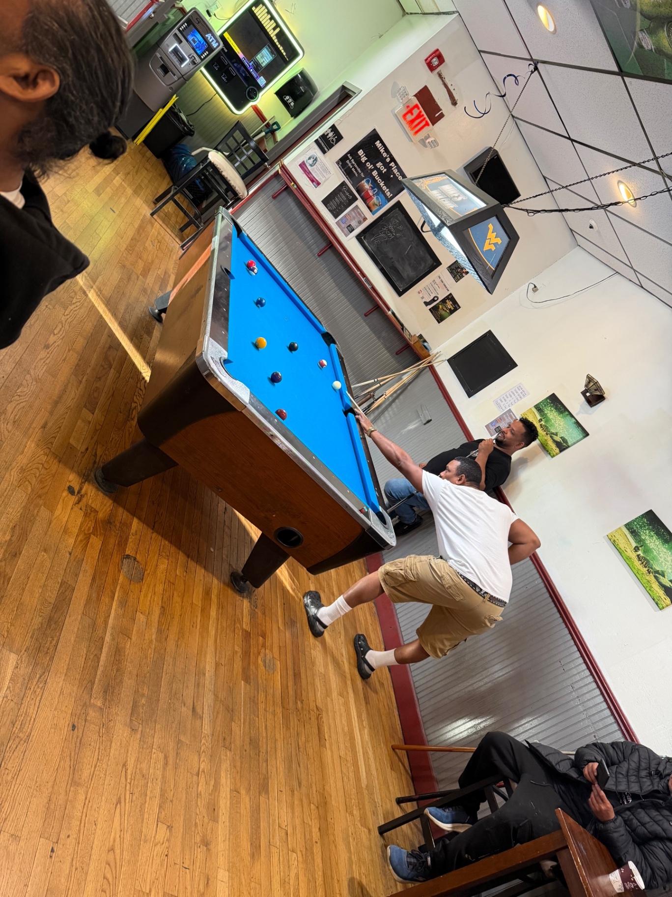 Players competing on a blue cloth table at Mike's Place