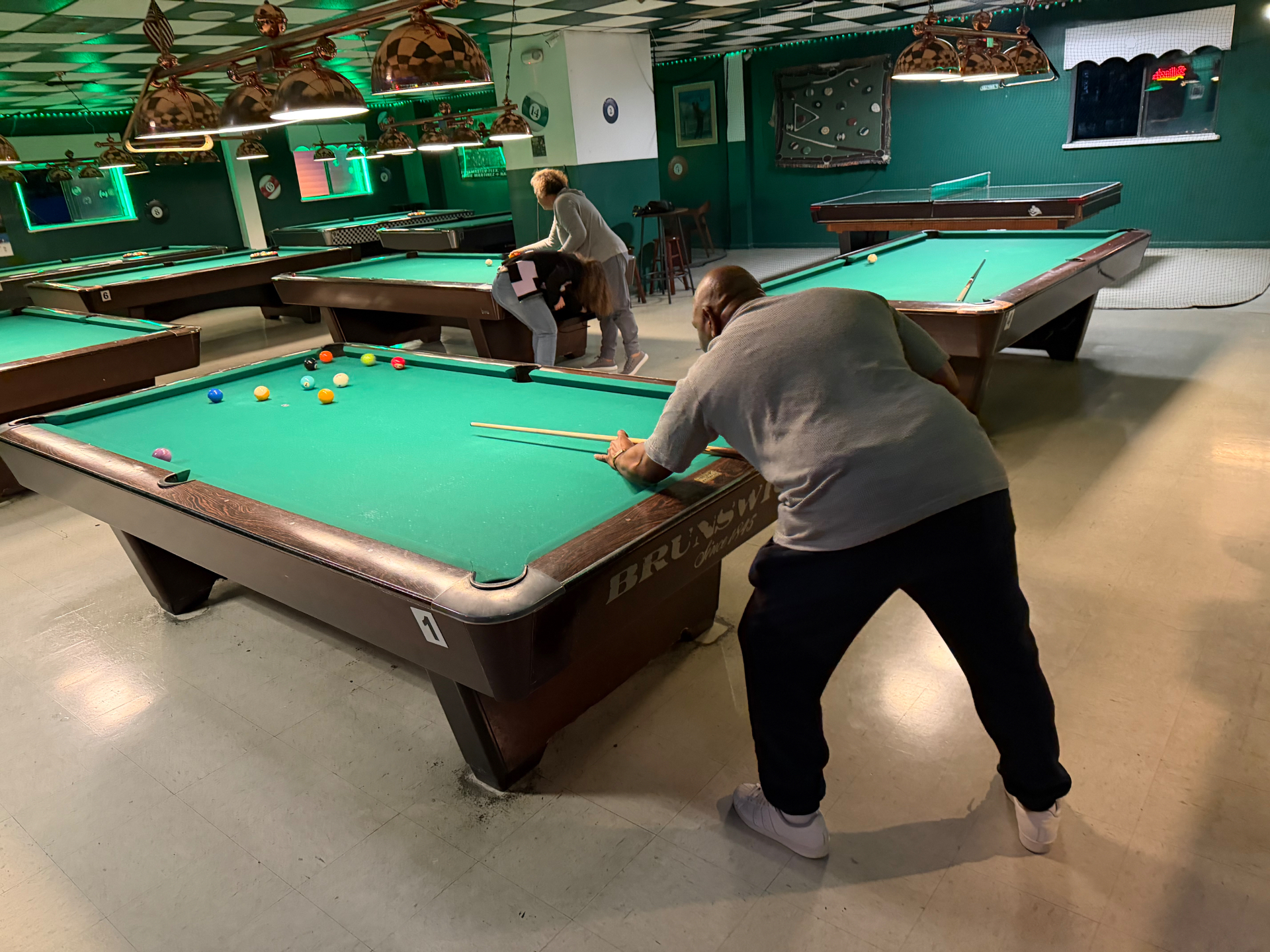 Player breaking on a green Brunswick table at PD Billiard